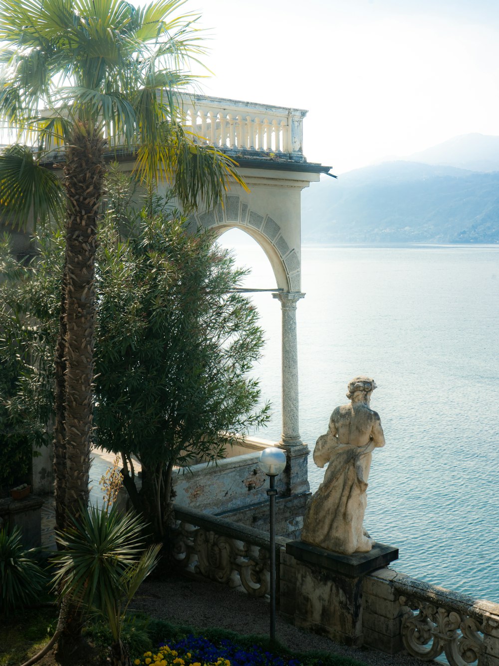 a statue in front of a large arch over water