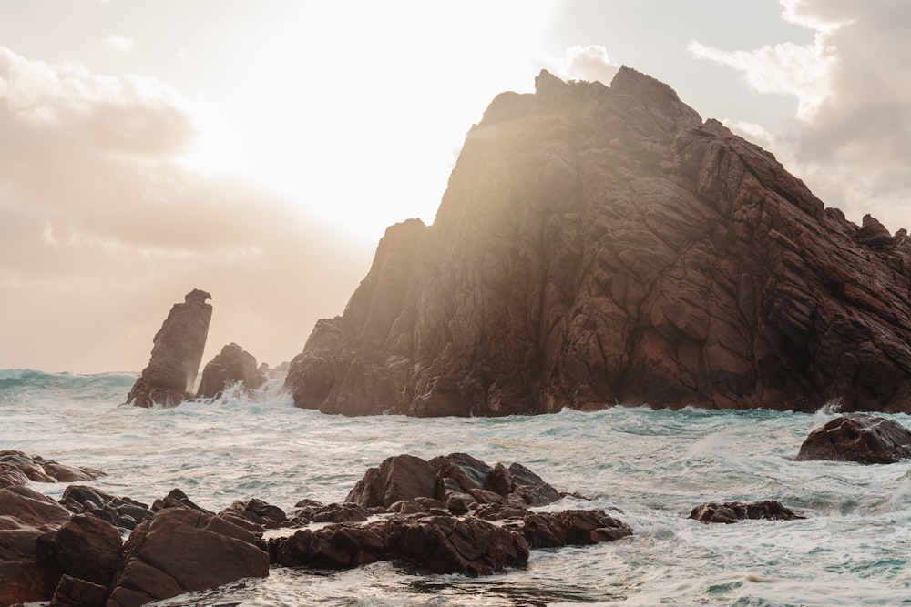 a rocky beach with a large rock formation in the middle