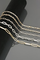 Chains and cuffs arranged artistically on a dark velvet surface, hinting at mystery.