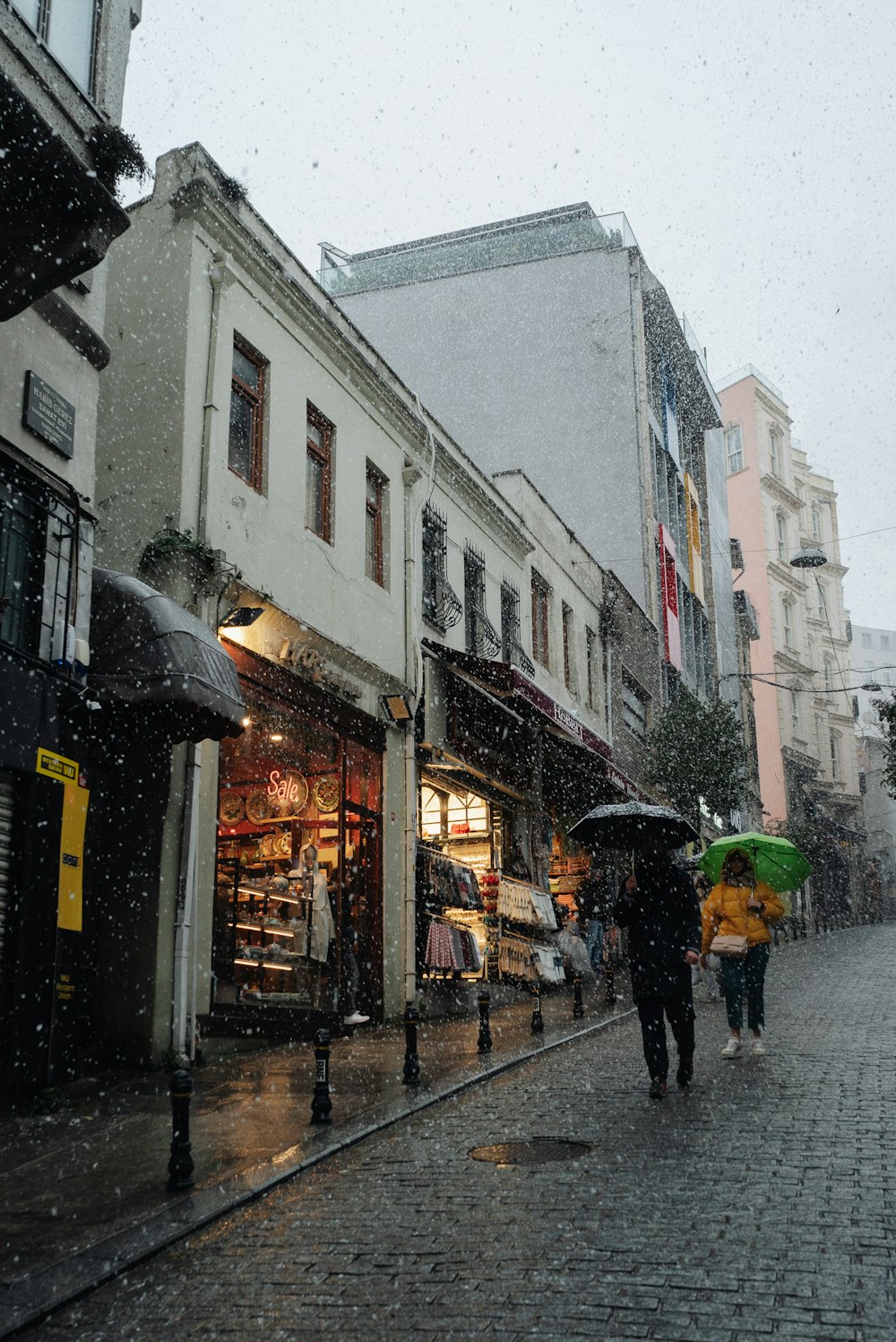 people walking down a street with umbrellas