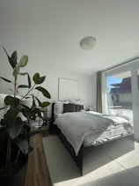 Bright hotel room with a large bed and natural light coming through the window