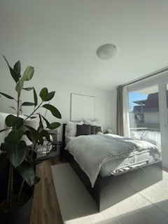 Bright bedroom with a large bed, soft linens, and a window view.
