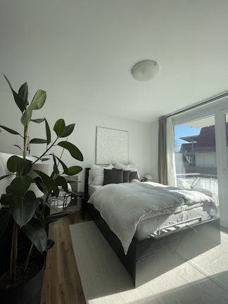 Bright bedroom with soft linens and large windows letting in natural light, creating a restful retreat.