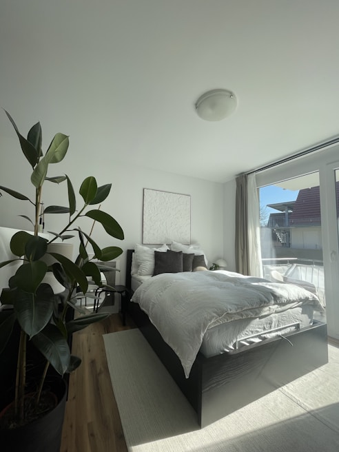 Bedroom featuring a large comfortable bed with crisp white linens and garden views