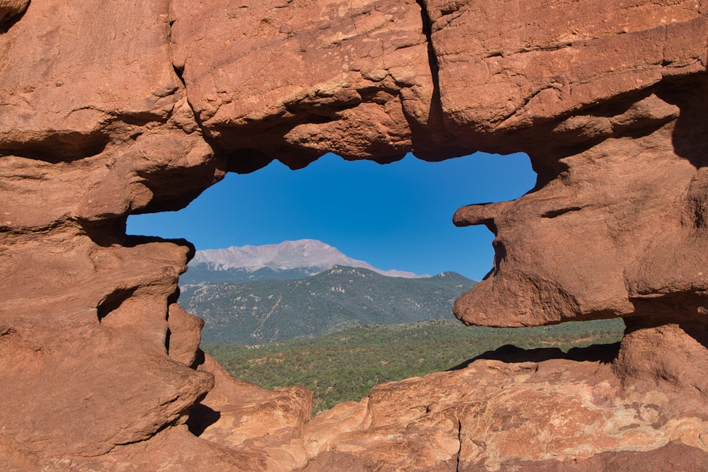 a view of a valley through a rock archway