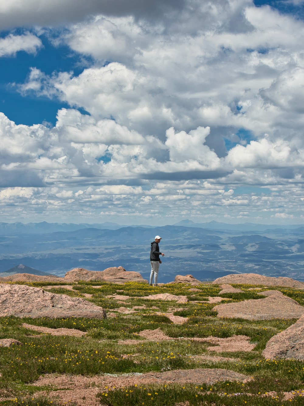 a person standing on a hill overlooking a body of water