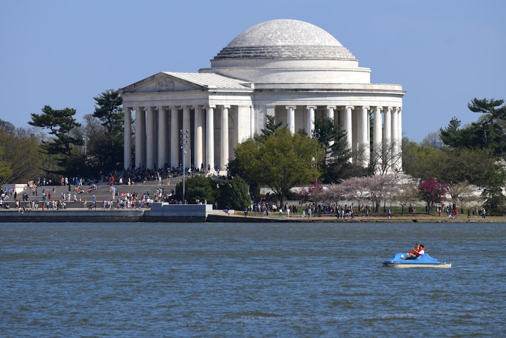 a white building with columns and a dome on top with Jefferson Memorial in the background