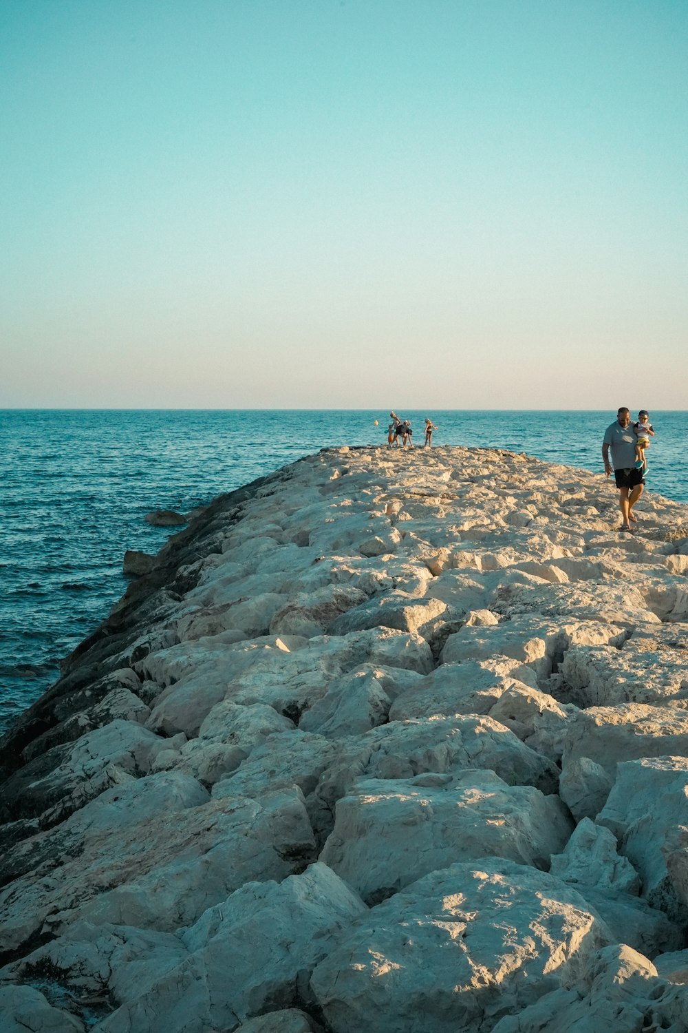 people walking on a rocky beach