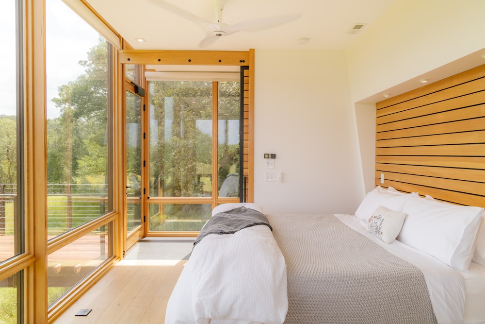 a bedroom with a bed and a large window