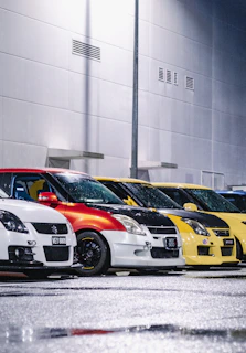 A row of cars gleaming after wash, lined up against the bold red and black Redline Wash building
