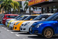 A row of colorful cars lined up neatly in the dealership lot, inviting visitors.