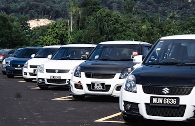Row of Japanese cars lined up outside a UK service center, gleaming under the sun.