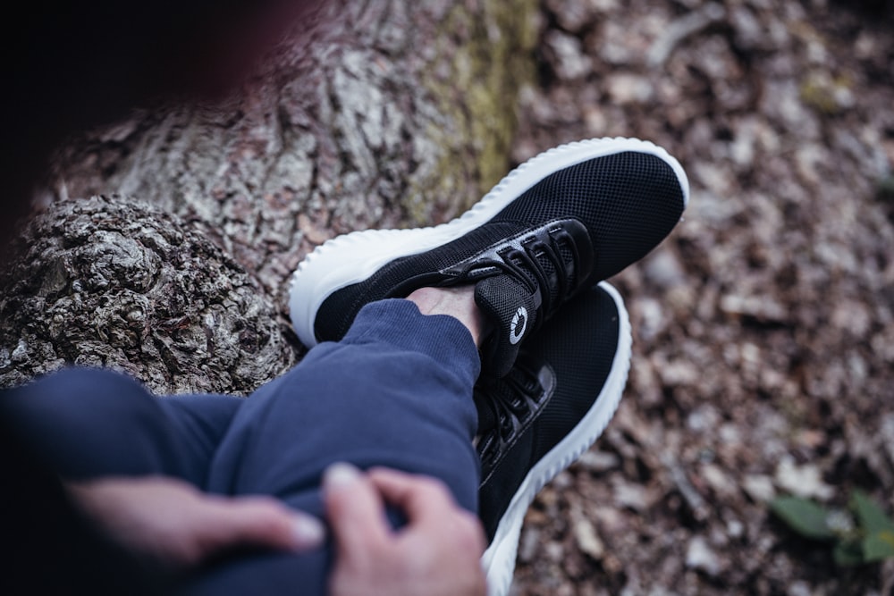 Die Füße einer Person in schwarzen Schuhen auf einem Felsen