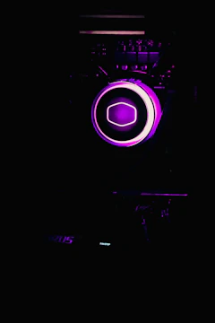 Close-up of a futuristic AI assistant icon glowing in purple on a dark background