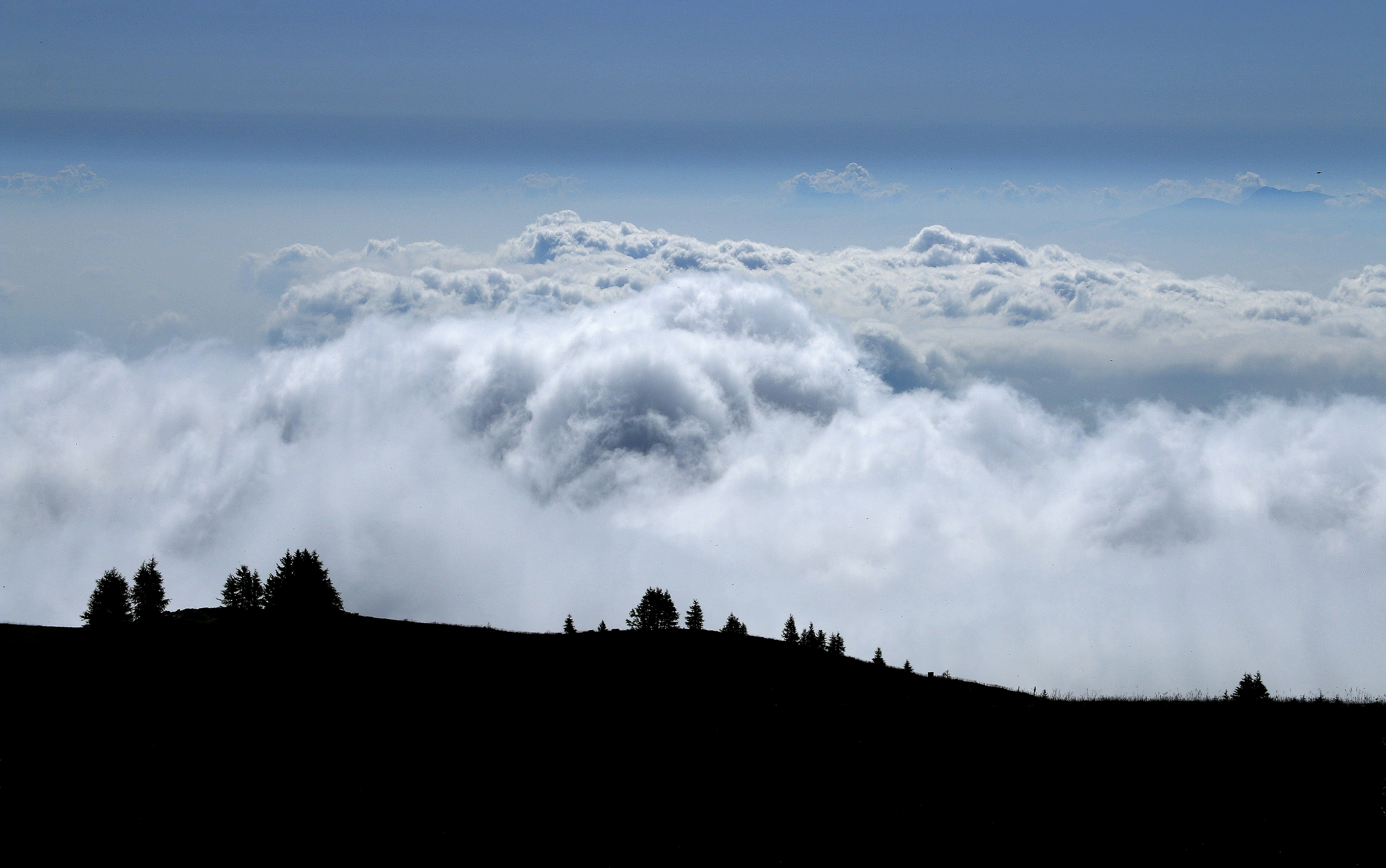 a mountain with clouds below
