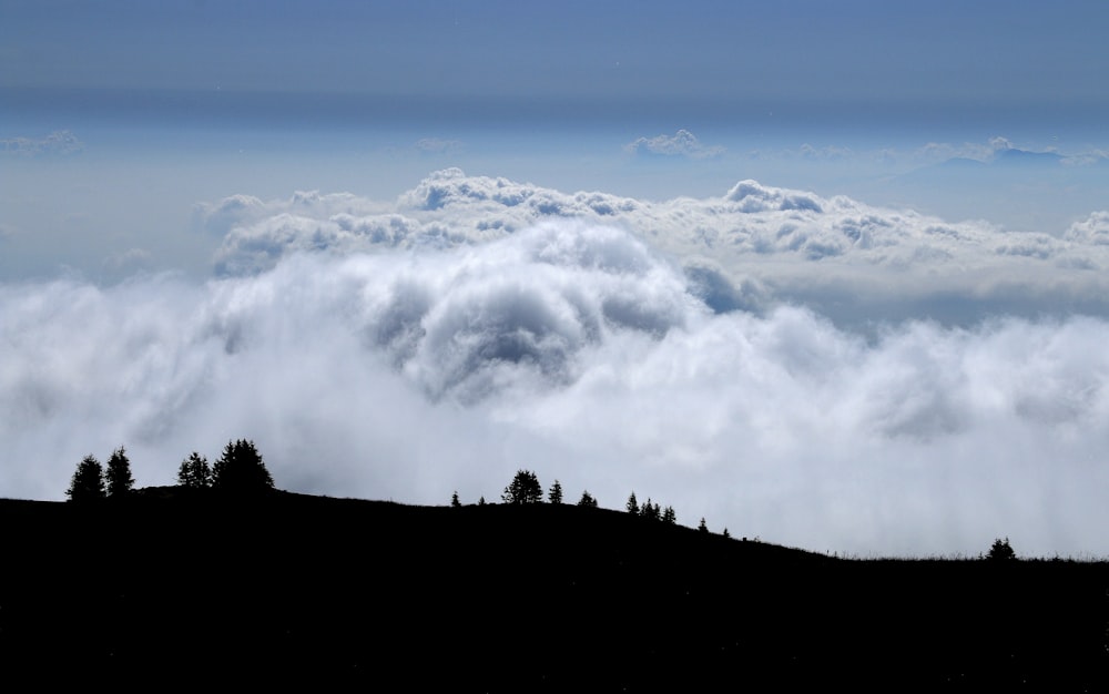 a mountain with clouds below