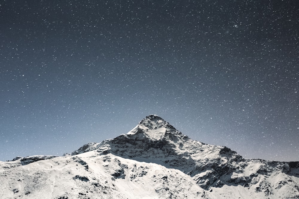 a snowy mountain with a starry sky above