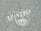 White text and a symbol are stenciled on a gray, speckled asphalt surface. The words appear to include 'The Town of Manteo' along with a circular emblem featuring a building-like figure.