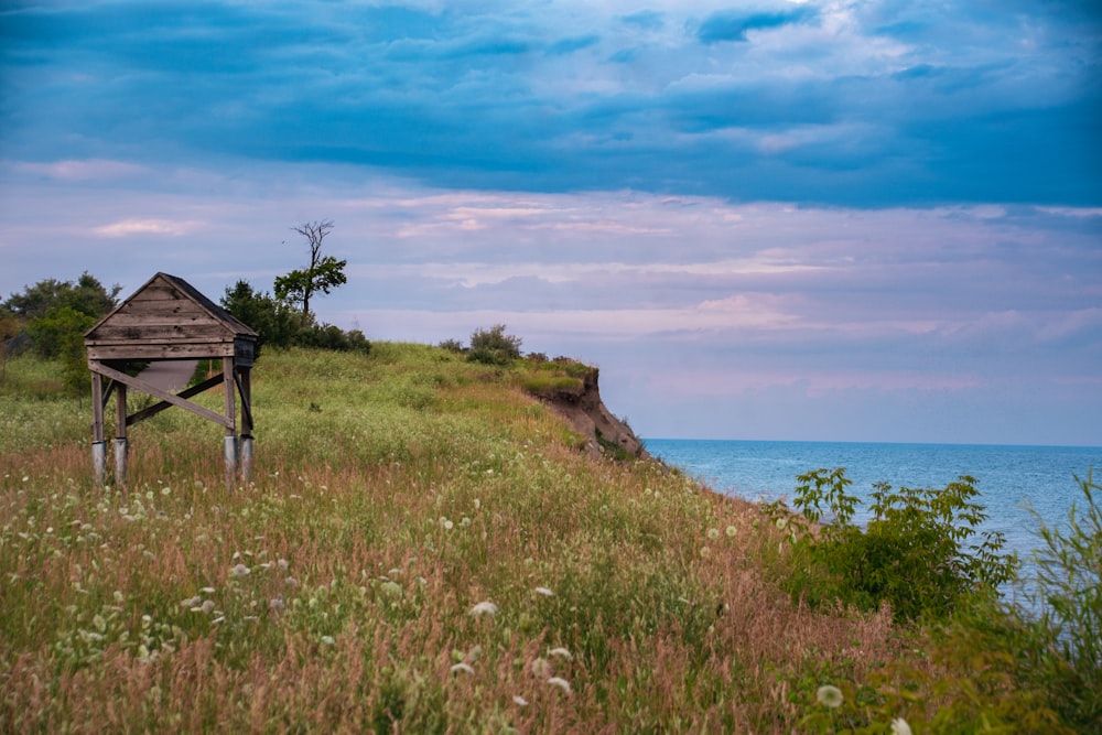 a wooden structure on a hill by the ocean