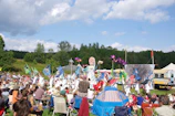 Parents and children enjoying an outdoor puppet show in a park