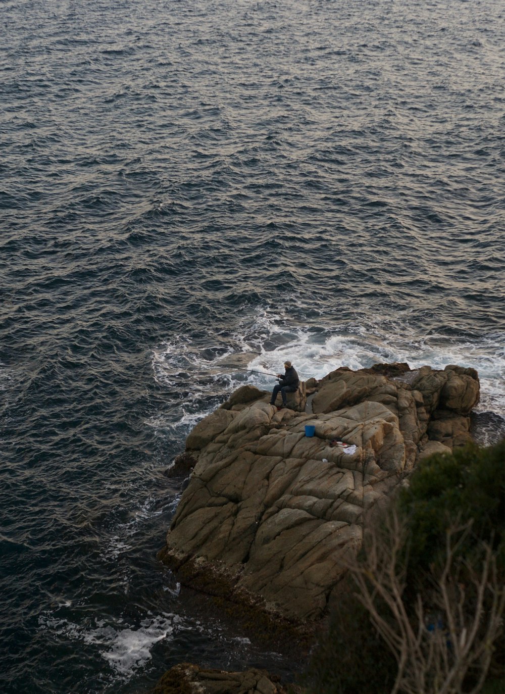 a group of people on a rock by the water