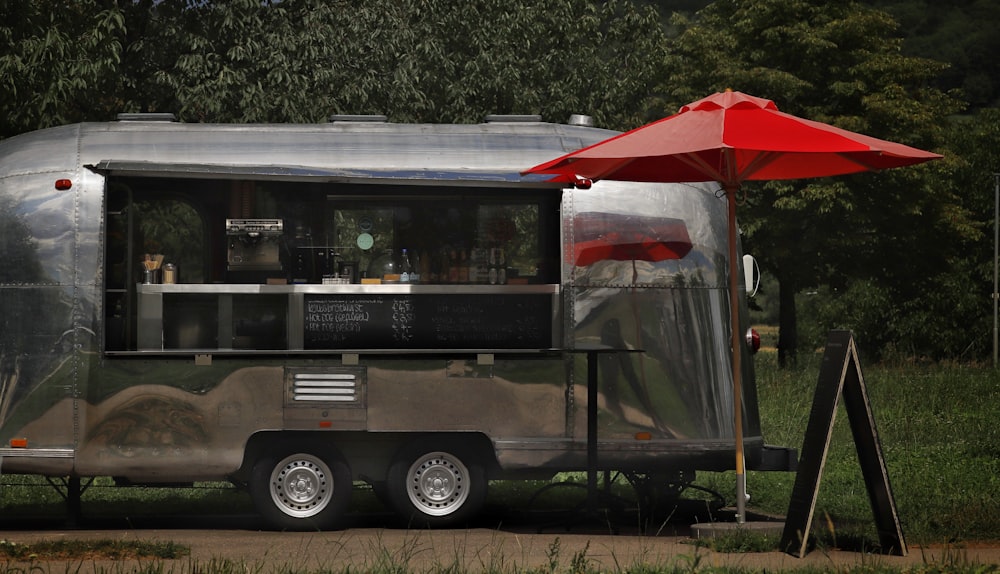 a food truck with a red umbrella