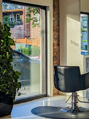 A modern salon interior with stylish chairs and bright natural lighting.