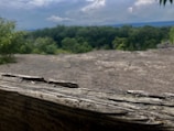 Close-up of a wooden balcony railing overlooking the forested hills.