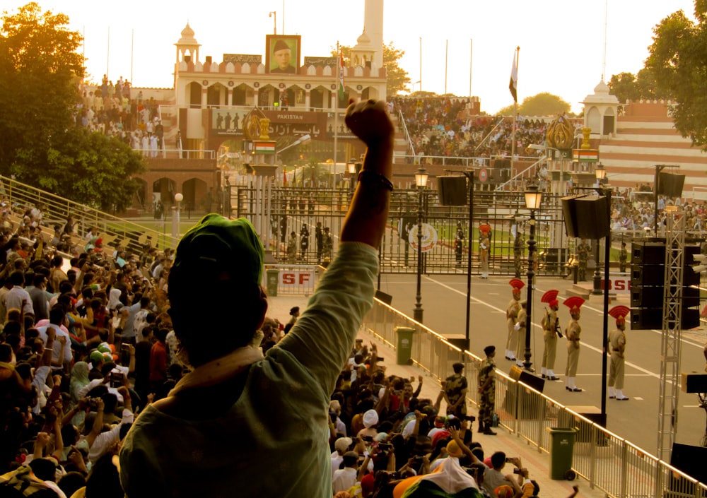 a person raising their hand in front of a crowd of people