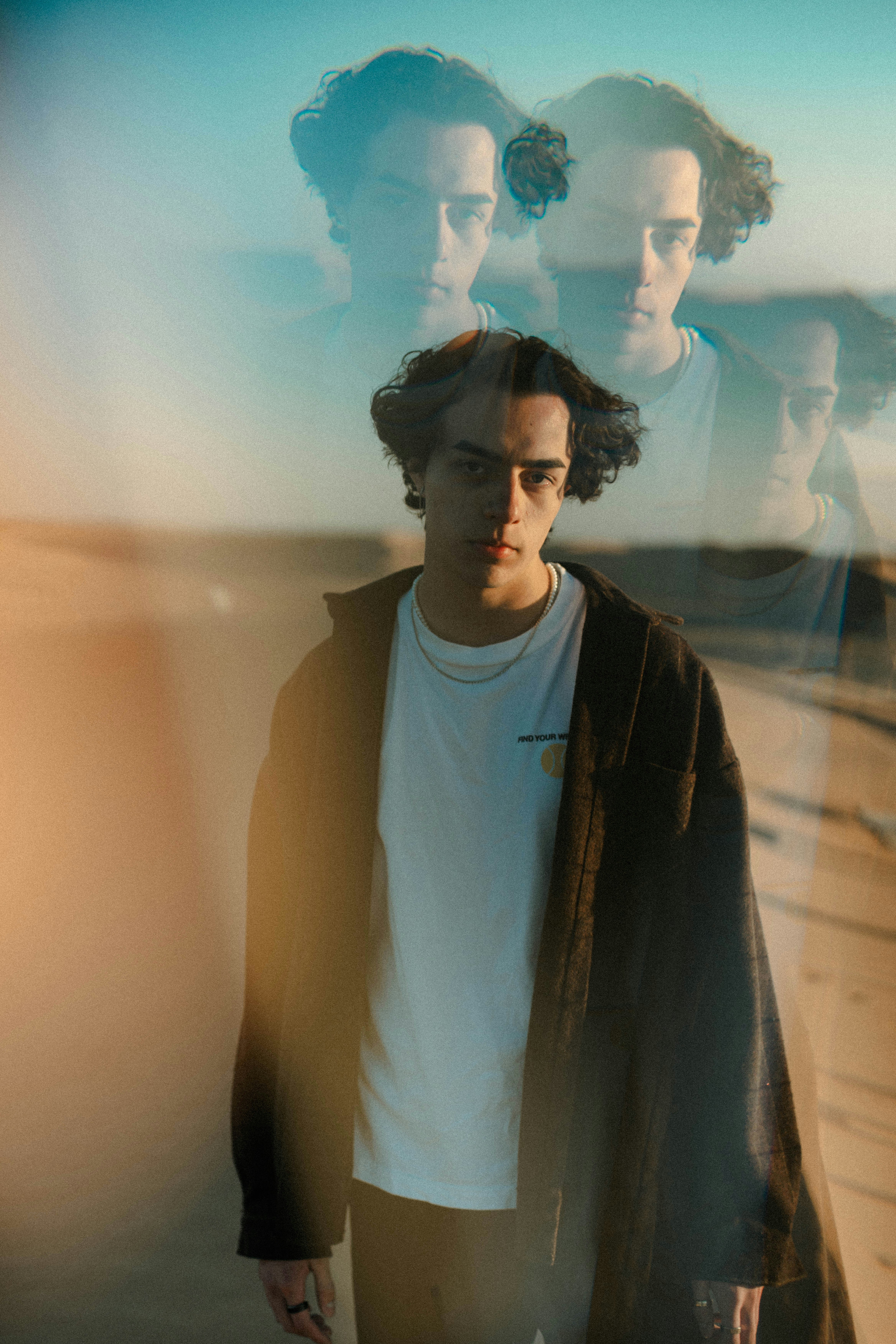 Young man in warm light, candid portrait, soft natural tones, bright airy setting