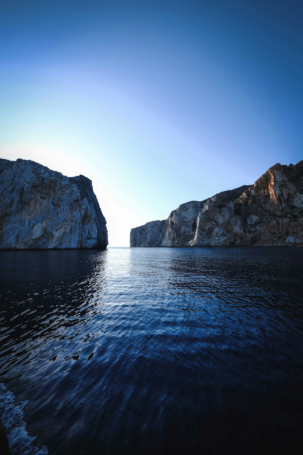 a body of water with large rocks in the background