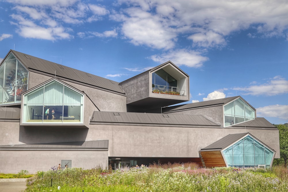 a building with windows and a grassy field in front of it