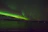 A stunning view of the Northern Lights dancing over a snowy Finnish forest.