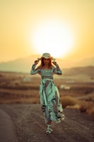 a person in a dress and hat holding a camera