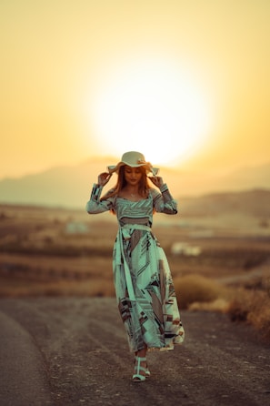 a person in a dress and hat holding a camera