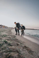 A group of happy divers preparing their gear on the shore before a dive.
