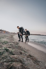 Friendly dive instructor helping a group prepare their gear on a sunny Red Sea beach.