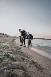 A group of happy divers preparing their gear on a sunny beach before a dive.