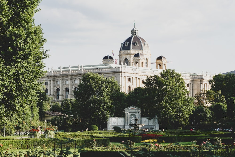 a large white building with a dome and a garden in front of it