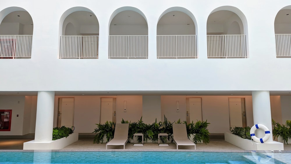 a pool with chairs and a building