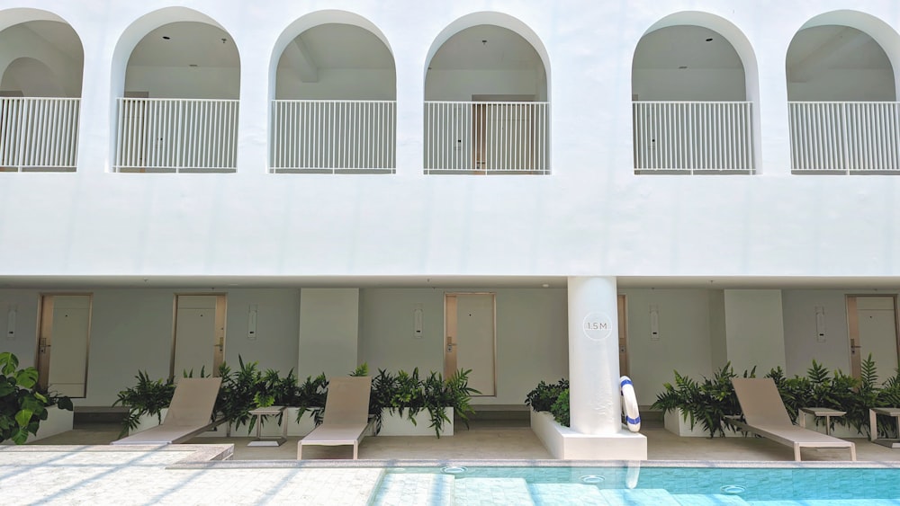 a building with a pool and chairs