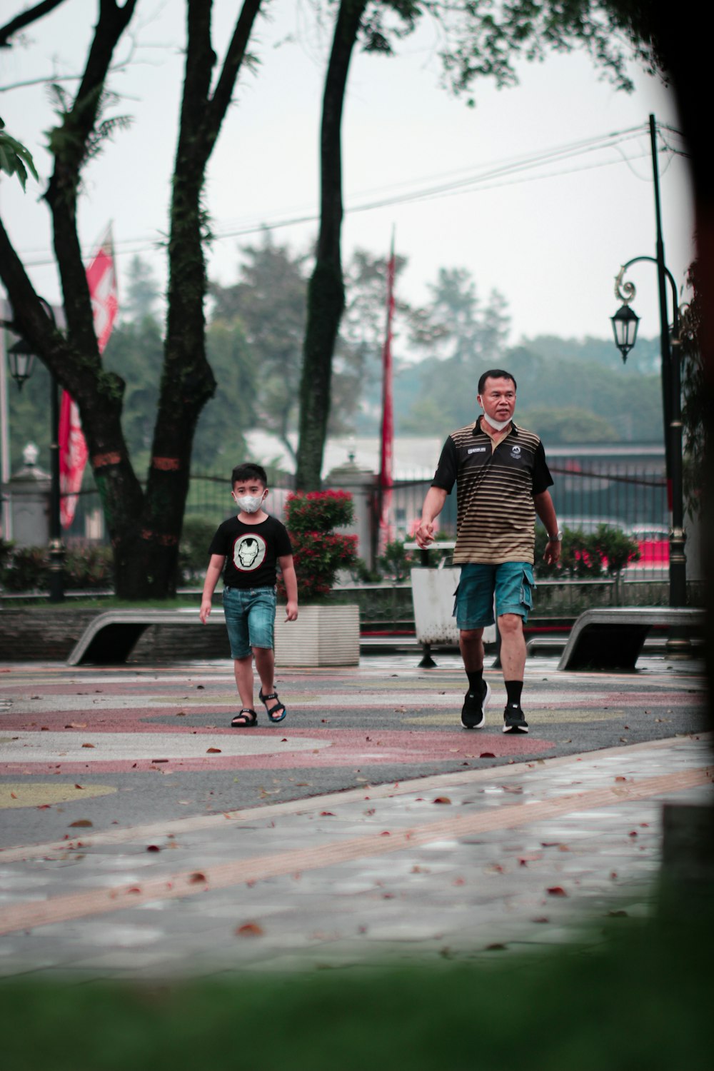 eine Person und ein Junge, die auf einem Bürgersteig gehen