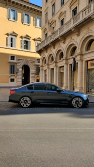 A sleek, clean black sedan waiting outside Rome Fiumicino airport with a friendly driver holding a name sign.