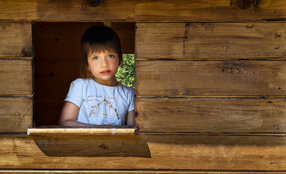 a child sitting in a wooden box
