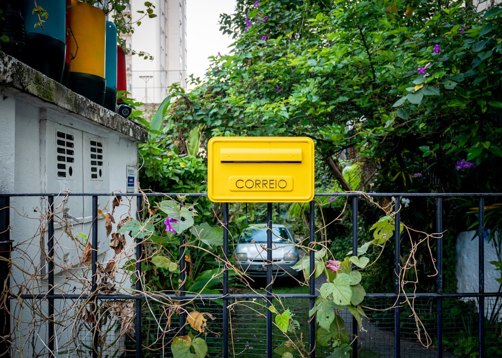 a yellow sign on a fence