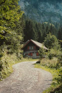 a house on a dirt road in the mountains