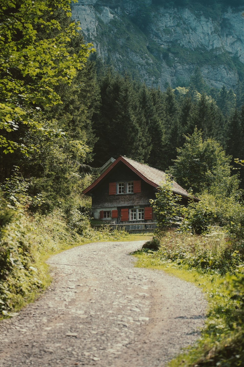 a house on a dirt road in the mountains