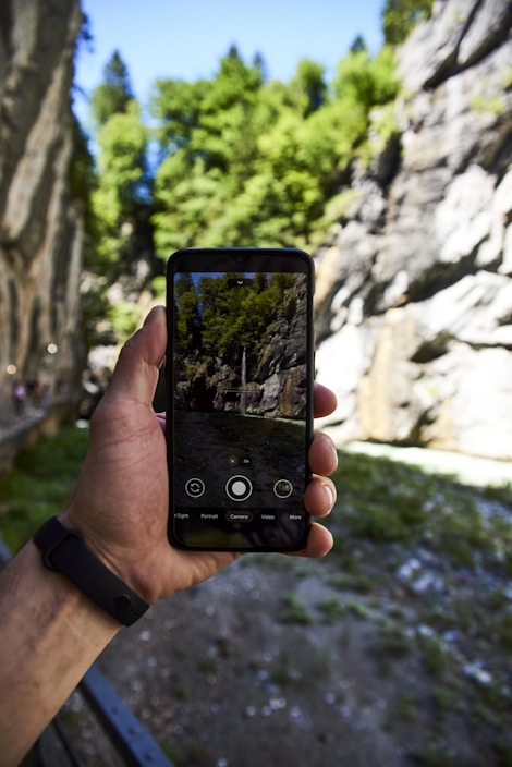 A traveler using a smartphone in a scenic Ecuadorian landscape.