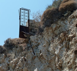 Rusty iron gate with jagged teeth-like spikes under a blood-red sky.