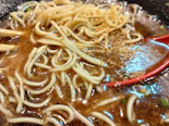 Close-up of a steaming bowl of ramen with fresh toppings and rich broth.